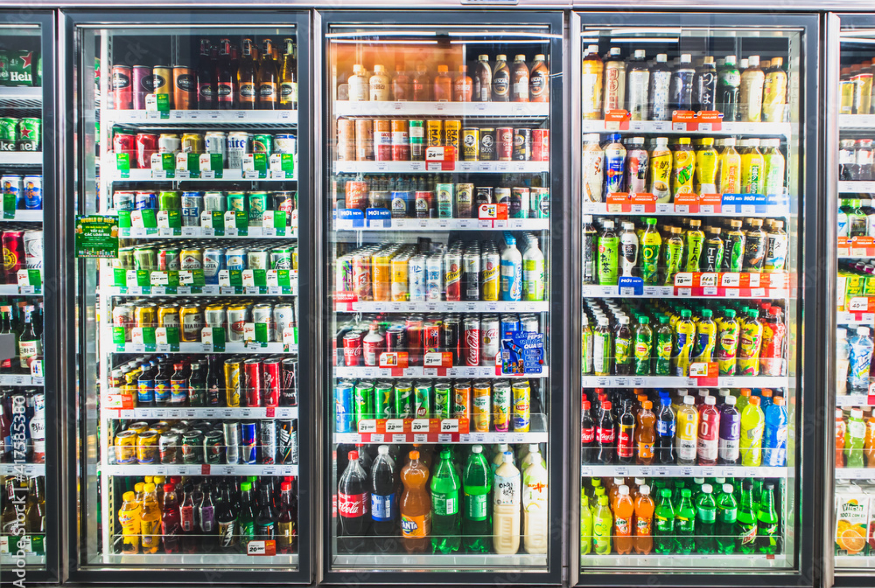 A row of glass cooler doors stocked with bottled and canned drinks.