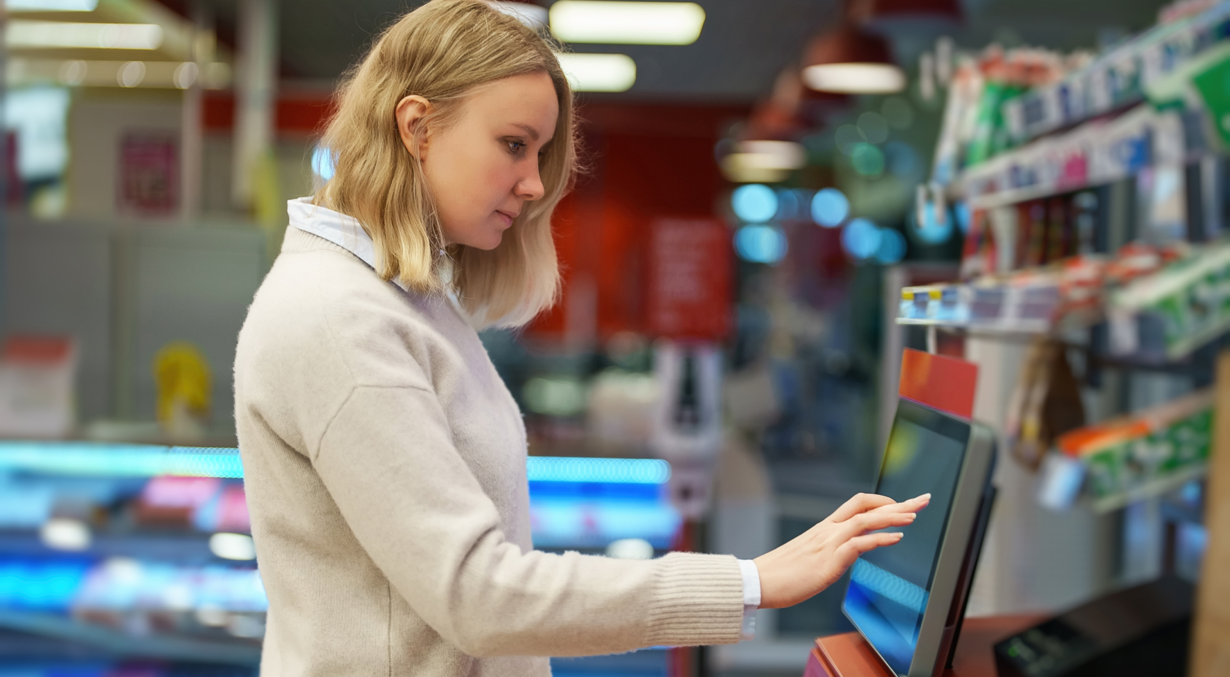 A shopper taps a touchscreen at a store counter.