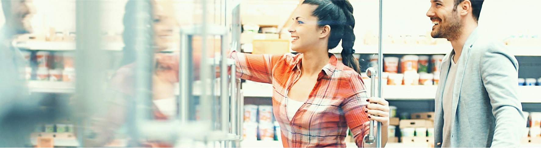 A smiling couple shopping together in a grocery store